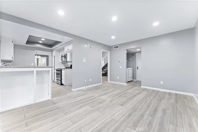 a view of a kitchen with wooden floor and a window