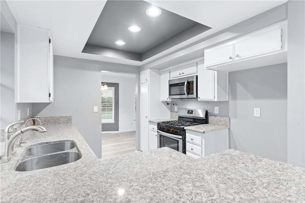 83 Weepingwood, Unit 35 Irvine, CA 92614 - Photo 9 of 19 a kitchen with granite countertop a sink stainless steel appliances and cabinets