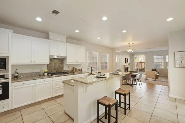 a large kitchen with stainless steel appliances granite countertop a sink stove and cabinets