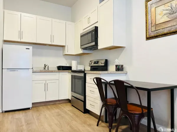 a kitchen with stainless steel appliances granite countertop white cabinets a sink and a stove