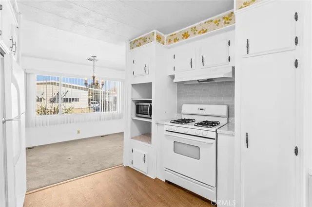 a kitchen with granite countertop white cabinets and white appliances
