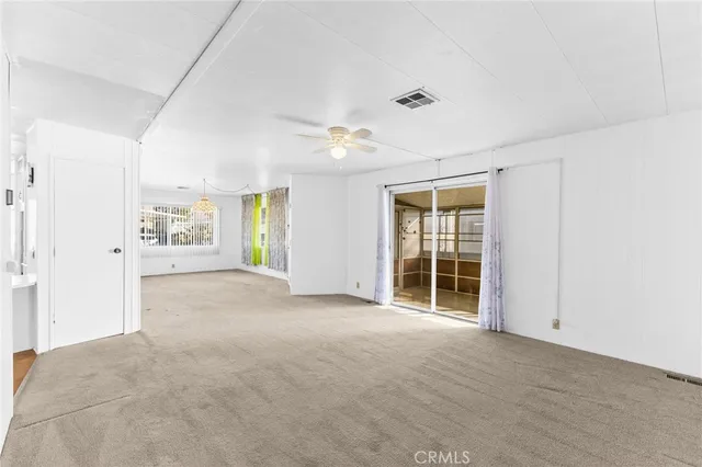an empty room with windows and cabinet