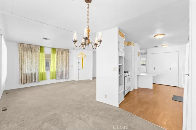 a view of a big room with windows and chandelier