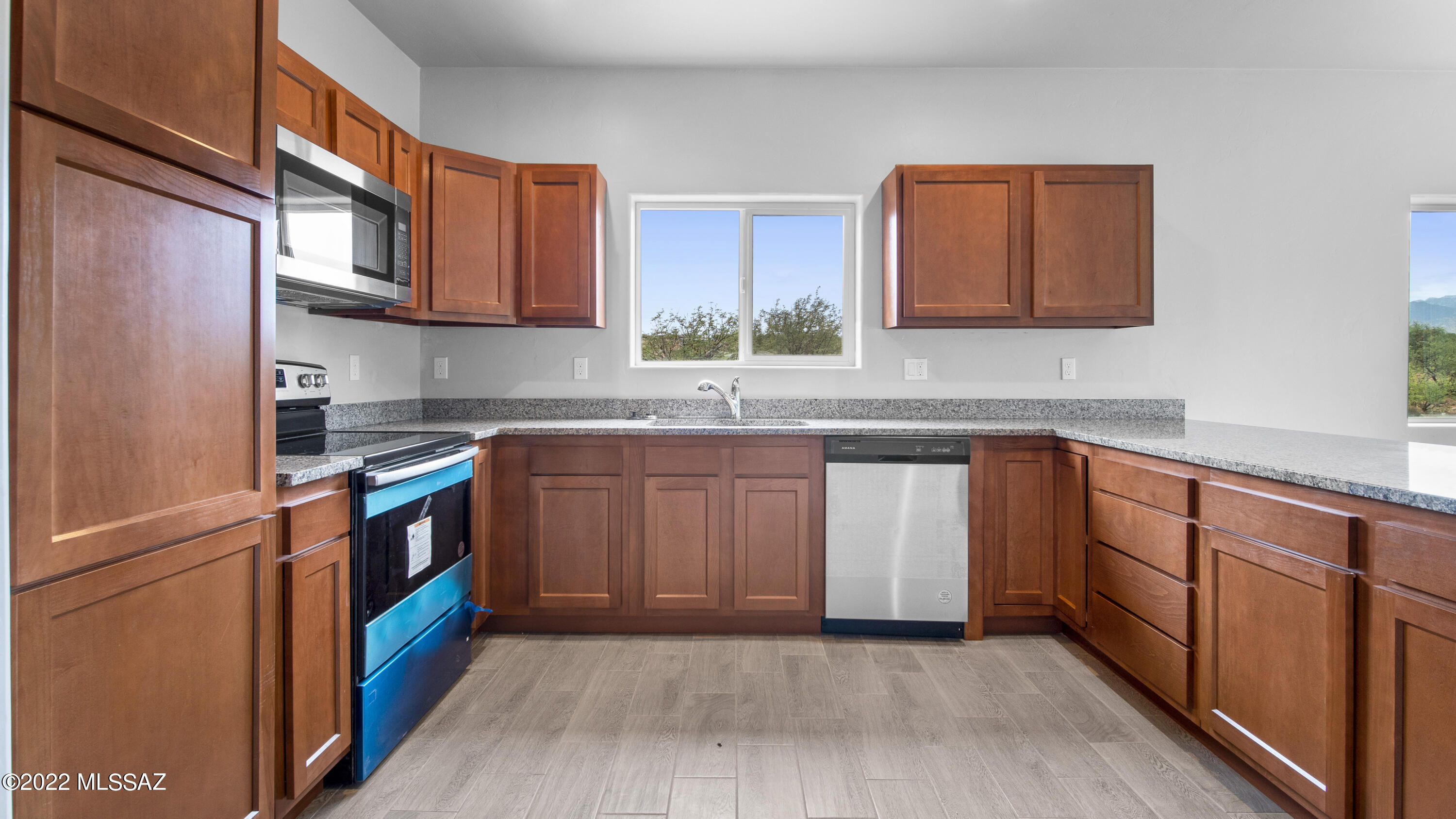 1843 Calle Mulata Rio Rico, AZ 85648 - Photo 24 of 27 a kitchen with stainless steel appliances granite countertop a stove a sink dishwasher and a refrigerator