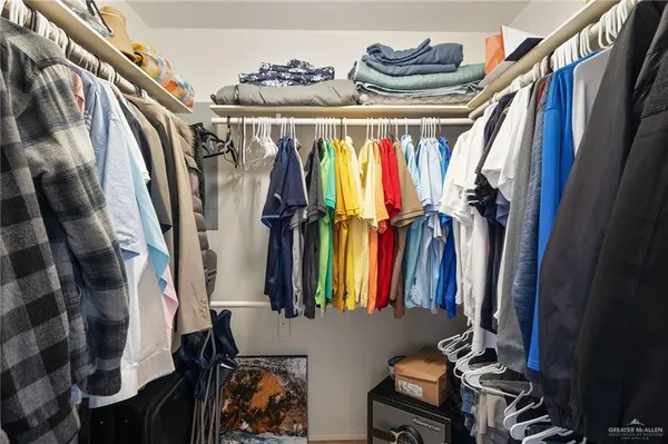 a view of walk in closet with clothes and shoes