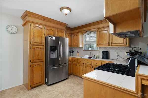 a kitchen with stainless steel appliances granite countertop a refrigerator and a stove