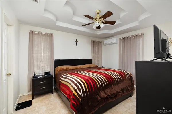 a bedroom with a bed a dresser and a chandelier