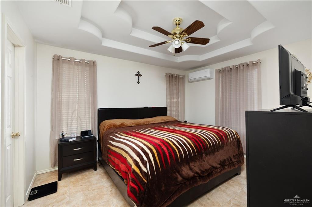 116 Margarito Street Roma, TX 78584 - Photo 6 of 29 a bedroom with a bed a dresser and a chandelier