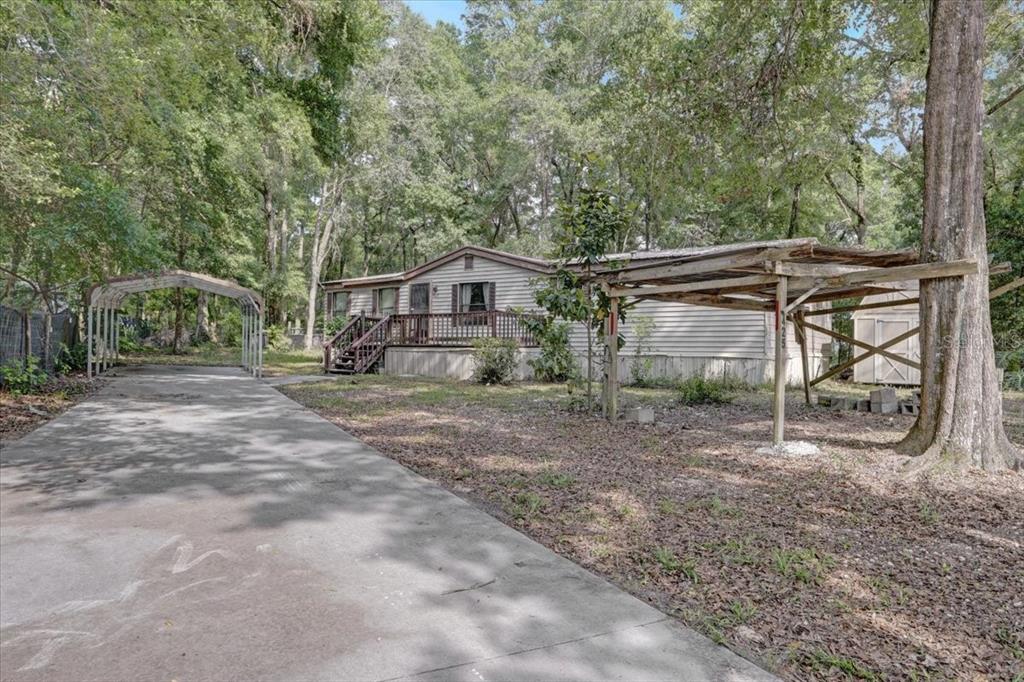 a backyard of a house with wooden fence and large trees