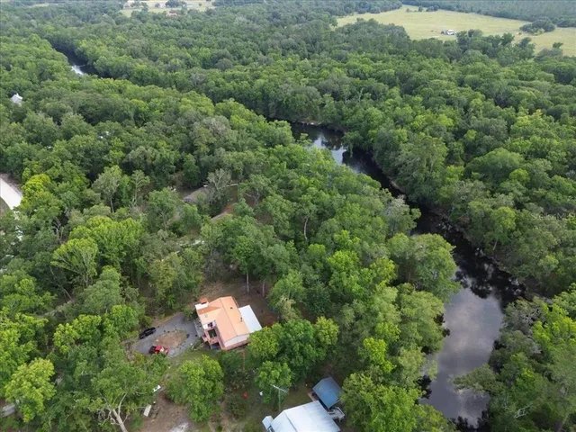 an aerial view of a house with a yard and outdoor seating