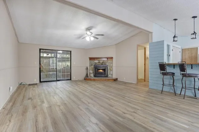 a view of empty room with a fireplace and wooden floor