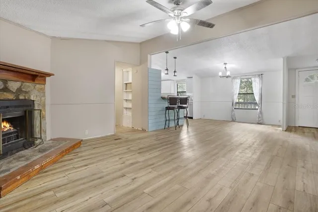 a view of empty room with wooden floor and fireplace