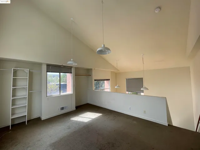 a view of an empty room with a window and fireplace