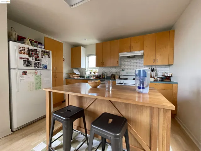 a kitchen with stainless steel appliances granite countertop a sink refrigerator and cabinets