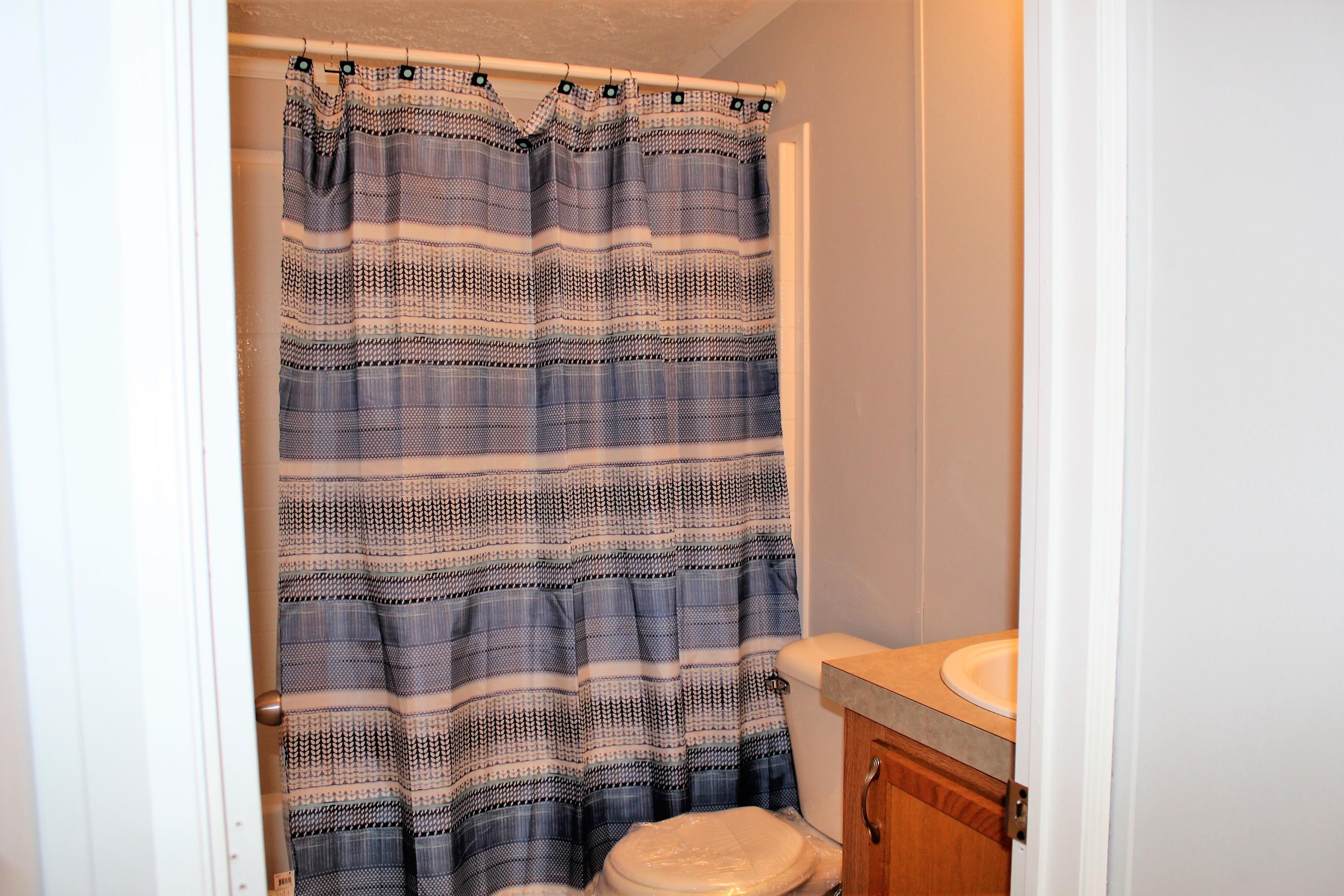 1140 Alex Brown Road Bonifay, FL 32425 - Photo 11 of 16 a bathroom with a shower toilet and sink