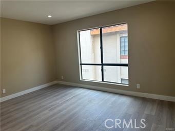 219 East Maple Street, Unit 9 Glendale, CA 91205 - Photo 2 of 13 an empty room with wooden floor and windows