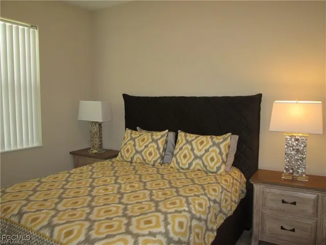 a large bed sitting in a bedroom next to a lamp