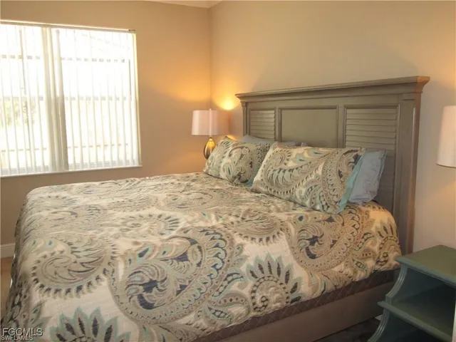 a large bed sitting in a bedroom next to a window