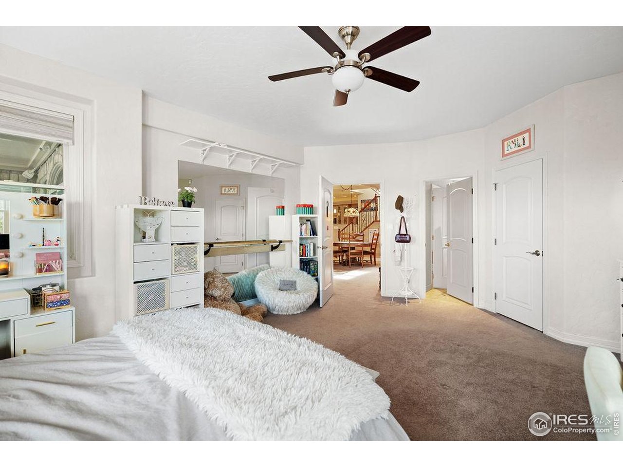 46 Sunset Lane Fort Morgan, CO 80701 - Photo 40 of 49 a bedroom with a large bed and a chandelier
