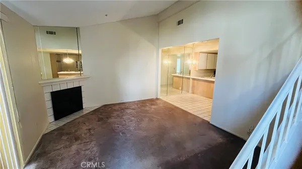 a view of empty room with wooden floor and fireplace