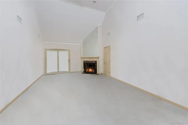 a view of empty room with a fireplace