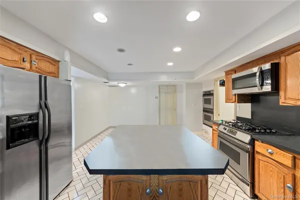 a kitchen with stainless steel appliances granite countertop a refrigerator a stove and a sink with wooden floor
