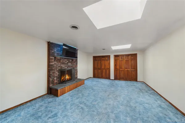 a view of an empty room with a fireplace and a window