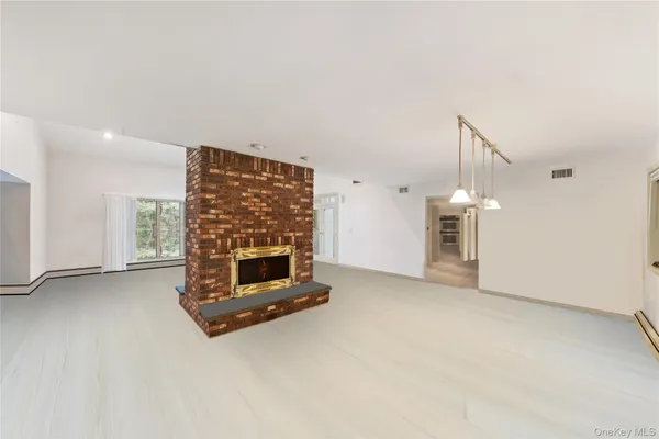 an empty room with a fireplace and window