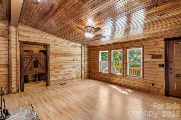a view of a livingroom with wooden floor and a ceiling fan