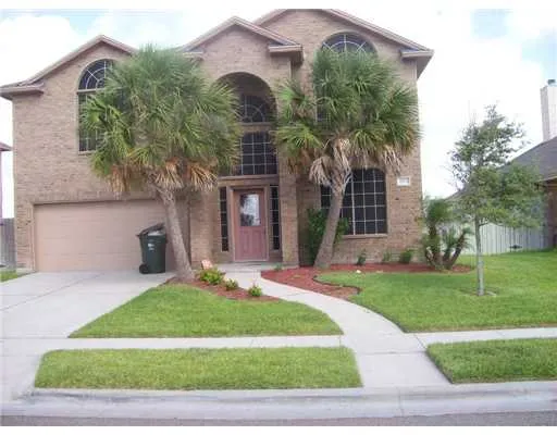 a front view of a house with a yard and potted plants