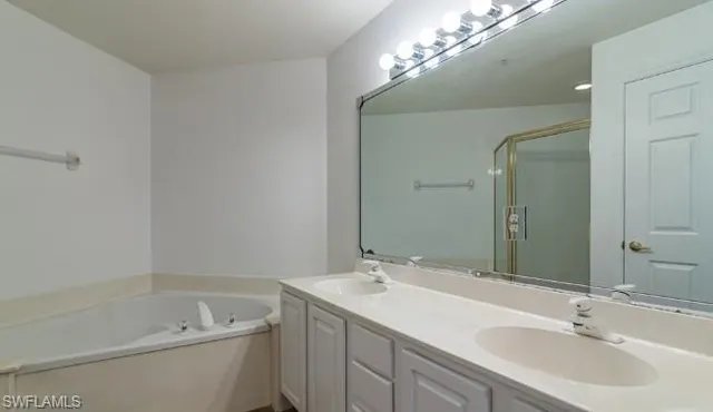 a bathroom with a tub a sink and mirror