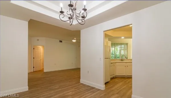 a view of a hallway with wooden floor and a bathroom
