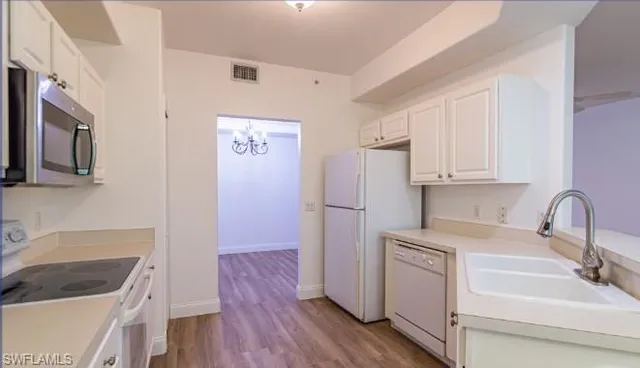a kitchen with a refrigerator sink and cabinets