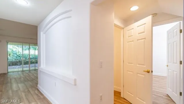 a view of a hallway with wooden floor and closet
