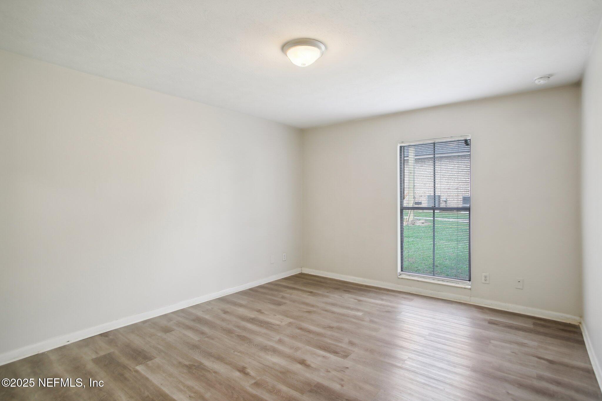 851 Bert Road, Unit 11 Jacksonville, FL 32211 - Photo 15 of 24 an empty room with wooden floor and windows