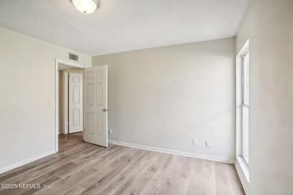 a view of an empty room and wooden floor