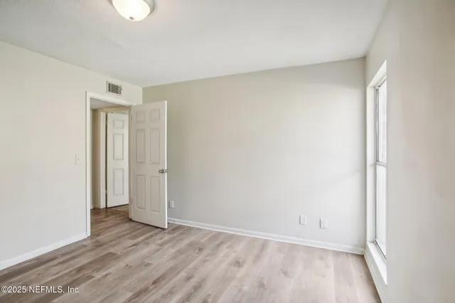 a view of an empty room and wooden floor