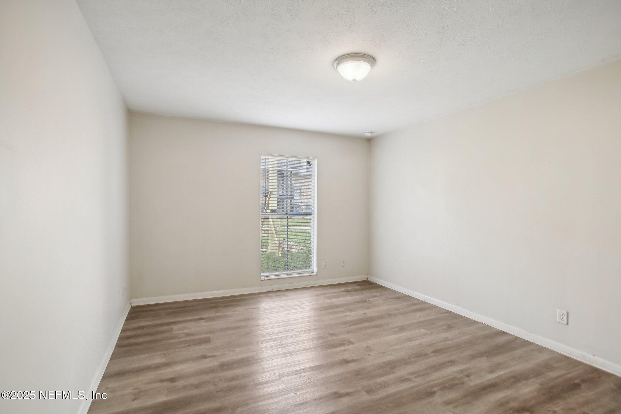851 Bert Road, Unit 11 Jacksonville, FL 32211 - Photo 19 of 24 an empty room with wooden floor and windows