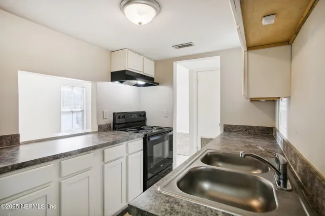 a kitchen with a sink a stove and a microwave oven