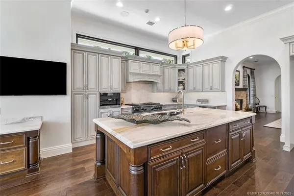 a dining room with furniture a chandelier and wooden floor