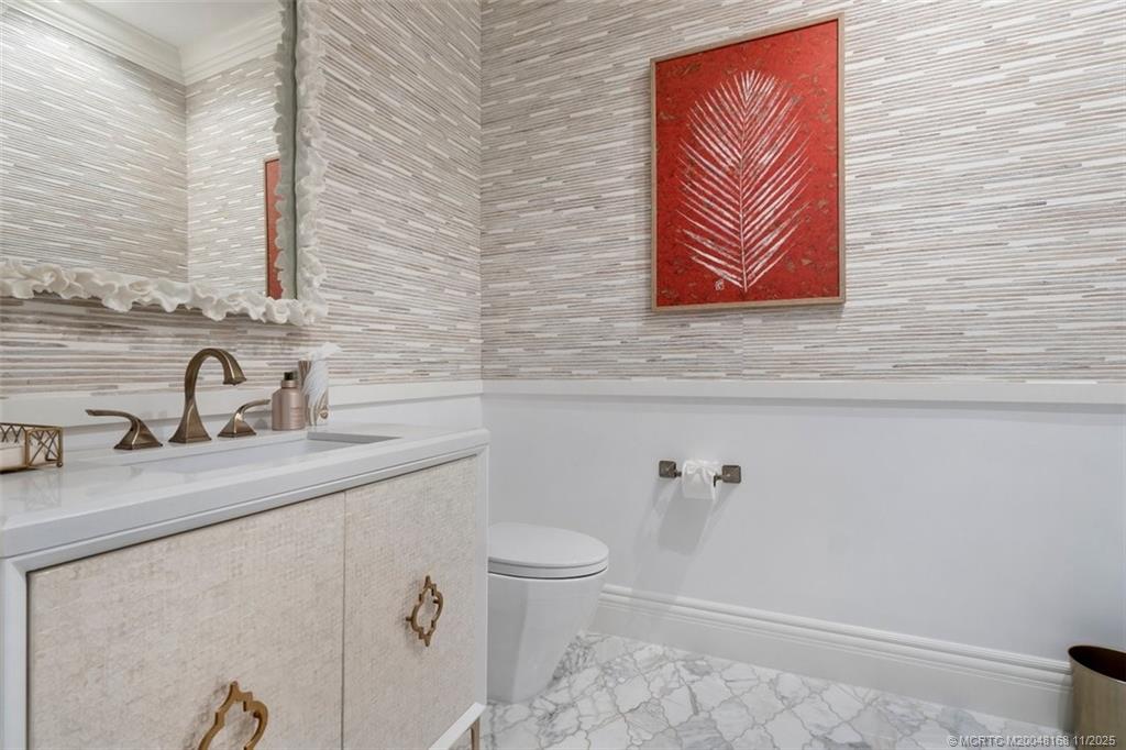 1904 Southeast Sailfish Point Boulevard Stuart, FL 34996 - Photo 19 of 64 a bathroom with a sink a toilet and mirror