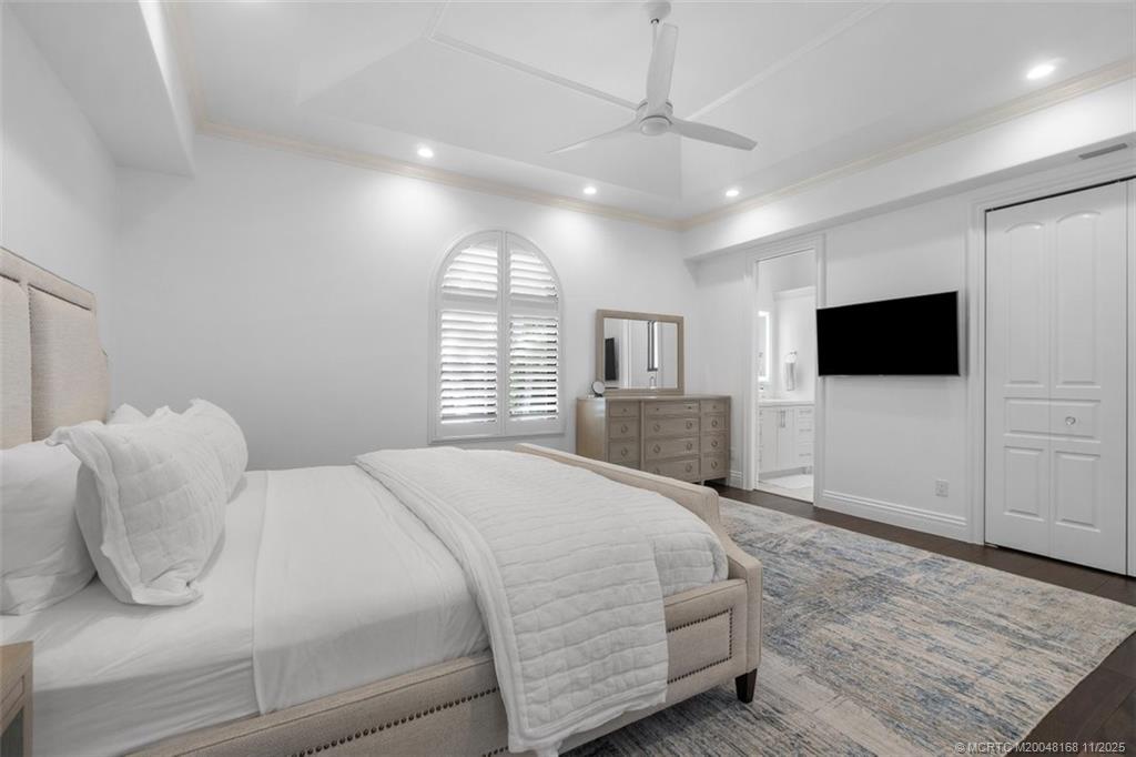 1904 Southeast Sailfish Point Boulevard Stuart, FL 34996 - Photo 31 of 64 a spacious bedroom with a bed and a flat screen tv