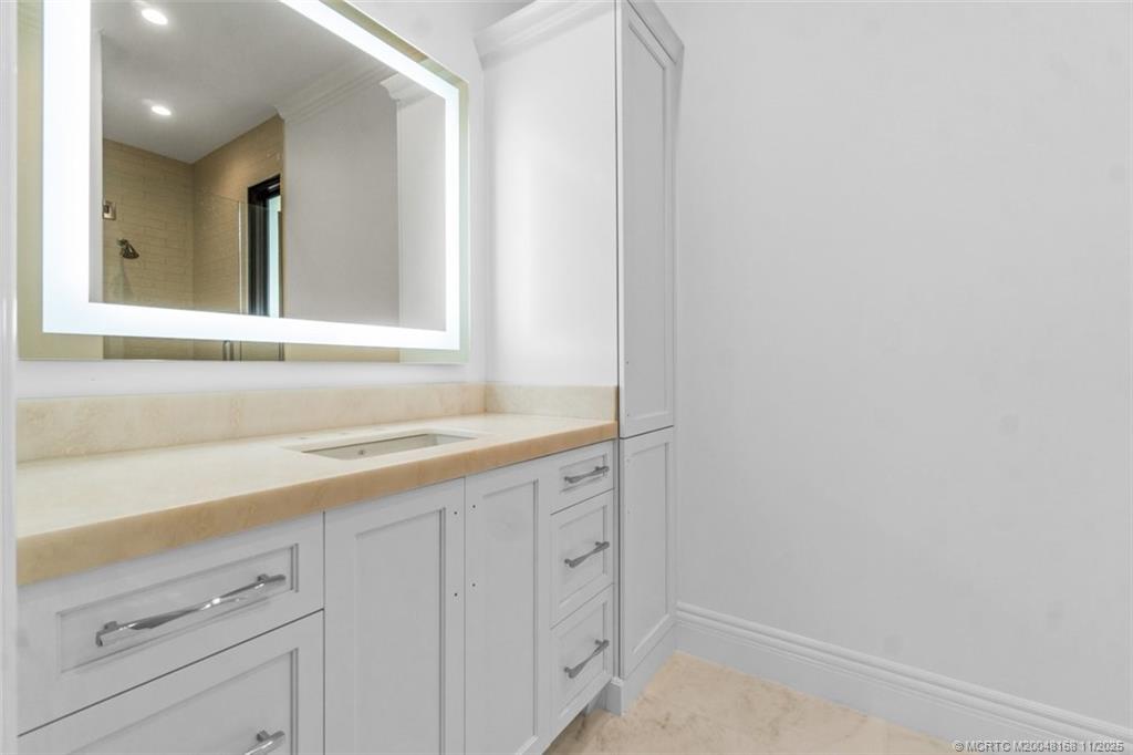 1904 Southeast Sailfish Point Boulevard Stuart, FL 34996 - Photo 34 of 64 a bathroom with a sink and a mirror