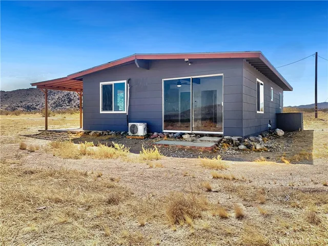 a view of a house with snow on the side of the road