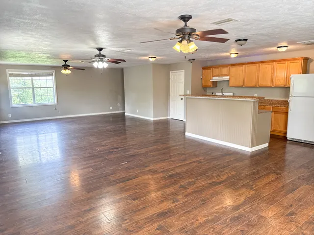 a kitchen with kitchen island granite countertop a sink stove and refrigerator