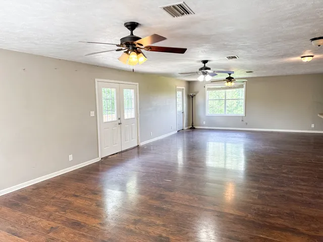 a kitchen with granite countertop a stove top oven a sink dishwasher and a refrigerator with wooden floor