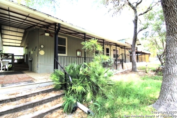 a front view of a house with a yard and potted plants