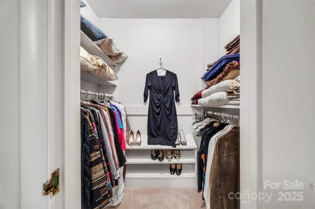 a view of walk in closet with clothes and shoes