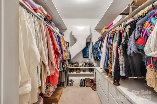 a view of walk in closet with clothes and shoes