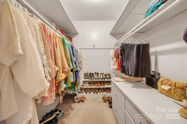 a view of walk in closet with clothes and shoes
